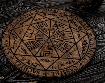 Könnte beinhalten: Ein rundes, hölzernes Dekorationsstück mit eingravierten Symbolen und Text. Das Design zeigt einen zentralen Stern, umgeben von geometrischen Formen und Namen wie Raphael und Michael. Der Artikel ist hellbraun.
