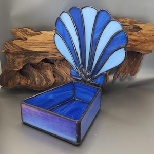 May include: A blue and white stained glass seashell trinket box. The box is open and the lid is shaped like a seashell.