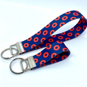 May include: A blue and red key chain with a donut pattern. The key chain has two silver key rings.