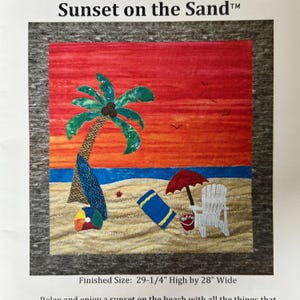 May include: A fabric art piece titled "Sunset on the Sand" depicts a beach scene. It features a palm tree, beach chair, umbrella, and a towel on a sandy beach, with a red and orange sunset sky. The finished size is 29.25 inches high by 28 inches wide.