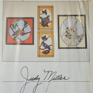 May include: A collection of four stained glass patterns by Judy Miller. The designs include a square panel with a bird on a branch, two vertical rectangular panels featuring birds on branches, and a rectangular panel depicting a unicorn with flowers.
