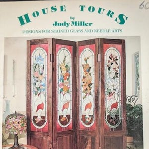 May include: A four-panel wooden room divider featuring stained glass inserts with floral vase designs. The top text reads HOUSE TOURS by Judy Miller DESIGNS FOR STAINED GLASS AND NEEDLE ARTS. A floral stained glass lamp sits in the foreground.