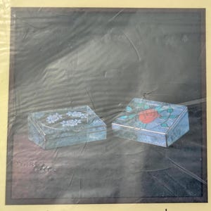 May include: Two rectangular boxes with hinged lids. The left box features a light blue marbled finish with a central oval containing three white rose illustrations. The right box has a similar blue marbled finish with a single red rose and green leaves.