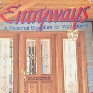 May include: A wooden front door with glass panels featuring a diamond grid pattern. Above the door, the text Entryways A Personal Signature for Your Home is displayed in red and blue script. A hanging lantern light fixture is visible on the right.