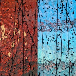 May include: Abstract artwork with a split composition. The left side features a textured, reddish-brown surface with black streaks and dark speckles. The right side displays a blue surface with similar black elements.