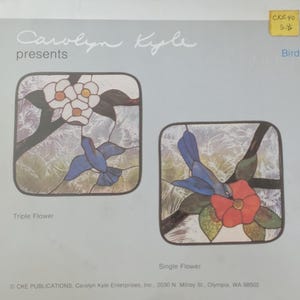 May include: A pattern sheet titled Carolyn Kyle presents Bird featuring two stained glass designs. The left design, Triple Flower, shows a blue bird near three white flowers. The right design, Single Flower, shows a blue bird near a red flower.