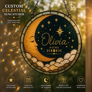 May include: Custom celestial suncatcher with a crescent moon and stars design. The personalized piece features the name "Olivia" and the date 10.23.2022. The suncatcher is round, with a dark teal background and gold accents, and is suspended by a chain.