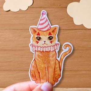 Pegatina holográfica de vinilo con un lindo gato payaso pelirrojo: pegatinas impermeables para agendas, diarios, álbumes de recortes, botellas de agua y espejos.