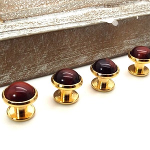 May include: Four gold cufflinks with red tiger's eye stone insets.