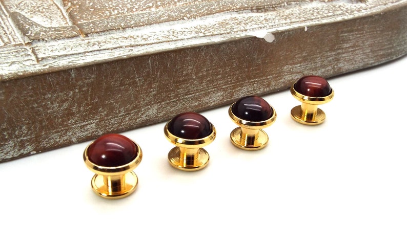 May include: Four gold cufflinks with red tiger's eye stone insets.