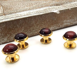 May include: Four gold cufflinks with red tiger's eye stone insets.