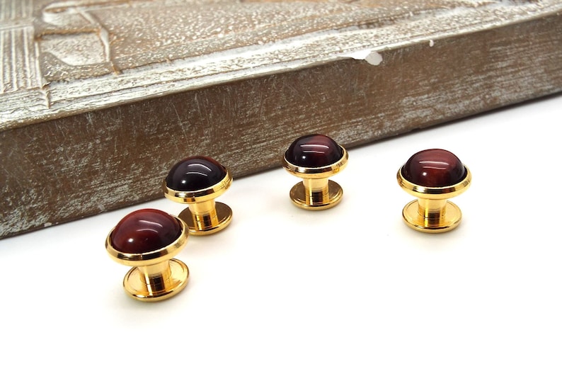 May include: Four gold cufflinks with red tiger's eye stone insets.