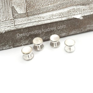 May include: Set of four silver cufflinks with white mother of pearl inserts.
