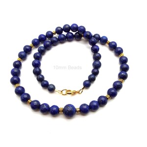 May include: A necklace featuring deep blue, 10mm beads. The beads are strung together with gold-colored accents and a gold clasp. The necklace is displayed on a white background.