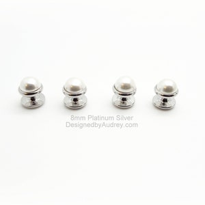 May include: Four 8mm pearl buttons with a platinum silver finish. The buttons are round and have a raised pearl centre. The buttons are arranged in a row on a white background.