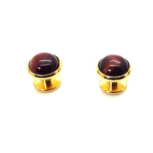 May include: Set of four gold-tone cufflinks with red tiger's eye stone insets.