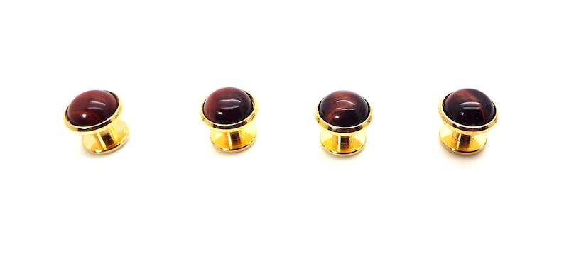 May include: Set of four gold-tone cufflinks with red tiger's eye stone insets.