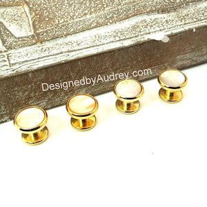Op de afbeelding: Set van vijf gouden manchetknopen met witte parelmoer inleg. DesignedbyAudrey.com