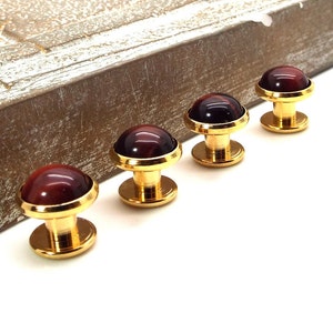 May include: Four gold cufflinks with red tiger's eye stone insets.