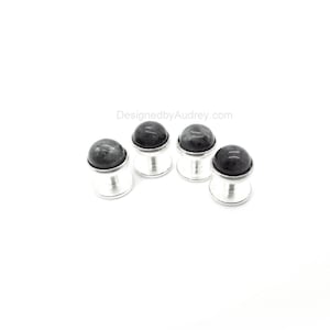 Op de afbeelding: Set van vier zilveren manchetknopen met zwarte edelsteen toppen. DesignedbyAudrey.com