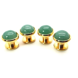 May include: Set of four gold cufflinks with green gemstone tops.