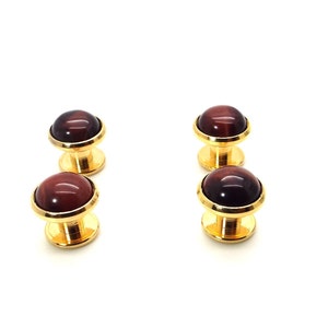 May include: Set of four gold cufflinks with red tiger's eye stone insets.