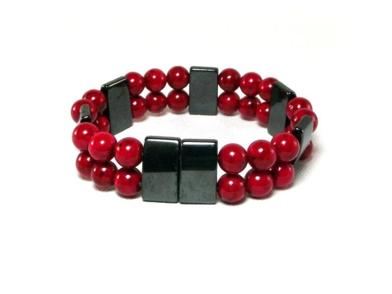 May include: A double-strand bracelet with red beads and black rectangular magnetic clasps.