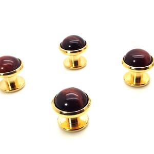 May include: Four gold cufflinks with red tiger's eye stone insets.