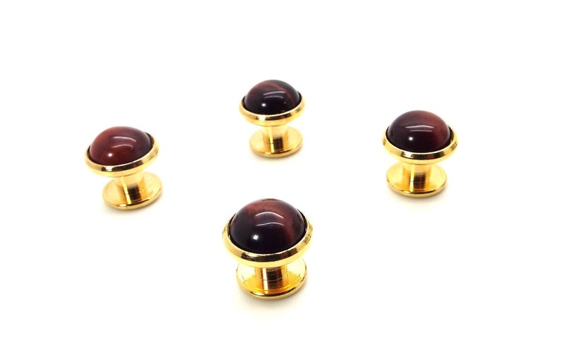 May include: Four gold cufflinks with red tiger's eye stone insets.