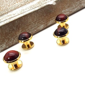 May include: Set of four gold cufflinks with red tiger's eye stone inlays.