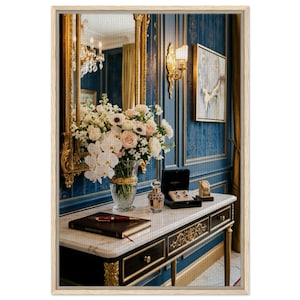 Peut inclure: Une console noire avec des garnitures dorées et un plateau en marbre supporte un vase en verre rempli de fleurs blanches et roses, un carnet marron foncé avec un stylo rouge, un petit flacon de parfum et une boîte à bijoux noire avec des boucles d'oreilles.