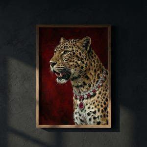 May include: A framed portrait of a leopard adorned with a diamond and ruby necklace. The leopard's coat is spotted, set against a deep red backdrop. The frame is wooden.