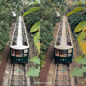 May include: Two green and white funicular cars ascend a steep track, viewed from above. The cars have glass roofs and are surrounded by lush greenery. The image is framed by leaves and the text "SHOT ON IPHONE" is visible at the bottom.