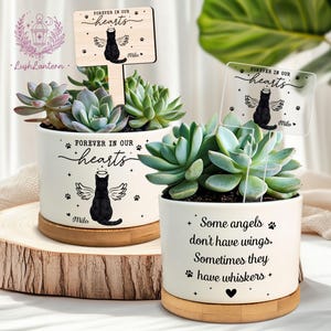 May include: Two white ceramic planters with succulents, each featuring a black cat design with angel wings and the text "Forever in our hearts." One planter has a wooden sign that reads "Forever in our hearts" and "Milo."