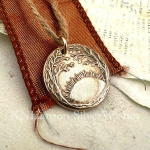 Amanecer, colgante de bronce hecho a mano con sol y bosque, original del artista
