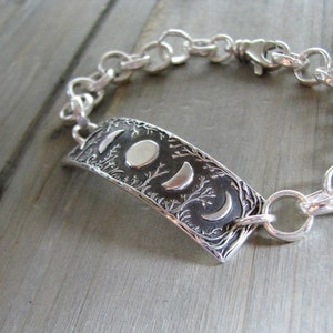 Puede incluir: Una pulsera de plata con un dije que representa un &aacute;rbol y tres fases de la luna. La pulsera est&aacute; hecha de una cadena de plata con un cierre de langosta.