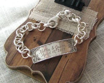 May include: A silver chain bracelet with a personalized rectangular charm engraved with "Kellie & Jason April 17, 2007".