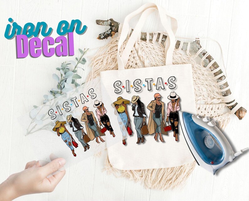 May include: Iron-on decal featuring a group of five women wearing hats and stylish outfits. The decal says "Sistas" in colorful letters.