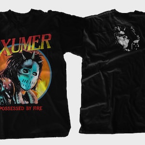May include: Black t-shirt with the word "EXUMER" in a colourful, retro font. The front features a graphic of a person wearing a mask, with the text "POSSESSED BY FIRE." The back has a black and white image.