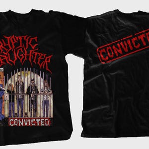 May include: Black t-shirt featuring the band name "Cryptic Slaughter" in red, stylized lettering above a graphic of people behind bars. The word "CONVICTED" is below the graphic. The back of the shirt has a red "CONVICTED" stamp.