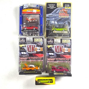 May include: A collection of five die-cast model cars in their original packaging. The set includes a red 1971 Dodge Charger Super Bee, a lime green 1970 Dodge Super Bee, an orange 1970 Dodge Super Bee, a magenta 1970 Dodge Super Bee, and a small lime green car.