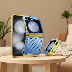 Op de afbeelding: Een blauwe en gele beschermhoes voor een opvouwbare telefoon. De hoes wordt in drie delen getoond, waarbij de telefoon gedeeltelijk open is. De hoes heeft een geometrisch ontwerp en een getextureerd uiterlijk. De telefoon ligt op een houten tafel.