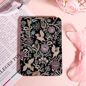 May include: A black rectangular case with a floral and dragon pattern. The design features stylized dragons, flowers, and foliage in shades of purple, beige, and green against a black background. The case is likely for a phone or tablet.