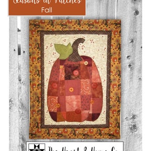 May include: A quilt pattern featuring a patchwork pumpkin with a brown stem and green leaves. The pumpkin is surrounded by a brown and gold floral border. The title "Seasons in Patches Fall" is at the top of the image. The Heart & Home Co. logo is at the bottom of the image.