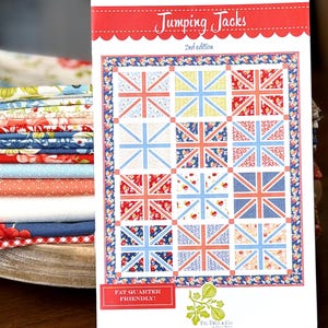 May include: A quilt pattern booklet titled Jumping Jacks 2nd edition by Fig Tree & Co. The cover displays a grid of twelve quilt blocks featuring Union Jack designs in various floral and geometric prints in red, blue, yellow, and white colors.