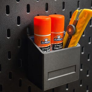 May include: A set of three ceramic mugs with a speckled, matte finish. The mugs are in shades of cream, light gray, and dark gray. Each mug has a simple, minimalist design and a rounded handle.