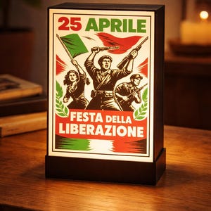Può includere: Lampada rettangolare con grafica raffigurante figure con bandiere e armi, con la scritta "25 APRILE" e "FESTA DELLA LIBERAZIONE" in rosso e verde. La lampada è su una superficie di legno.