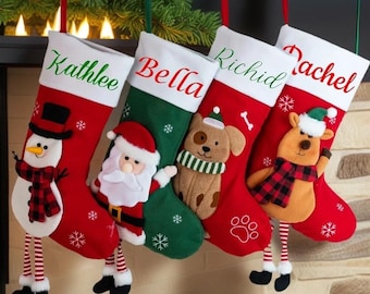 May include: Four Christmas stockings with white cuffs featuring the names Kathlee, Bella, Richid, and Rachel. The stockings display plush appliqués of a snowman, Santa Claus, a dog, and a reindeer, all accented with red and white snowflake patterns.