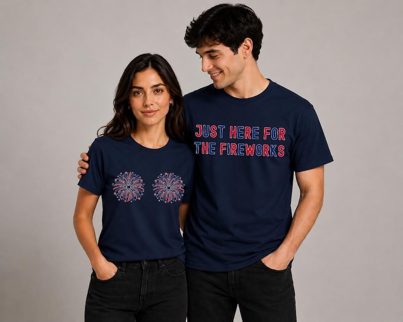 A man and a woman wearing matching navy blue t-shirts with the text "Just here for the fireworks" and a graphic of fireworks.
