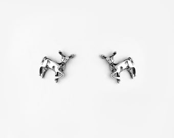 May include: A pair of silver deer stud earrings. The deer are facing forward with their heads tilted up.